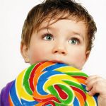 Niño con piruleta o chuche que aumentan la caries.